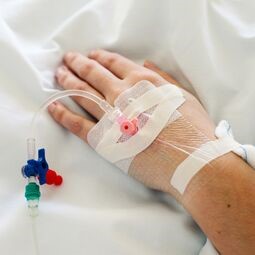 IV drip inserted in woman's hand.